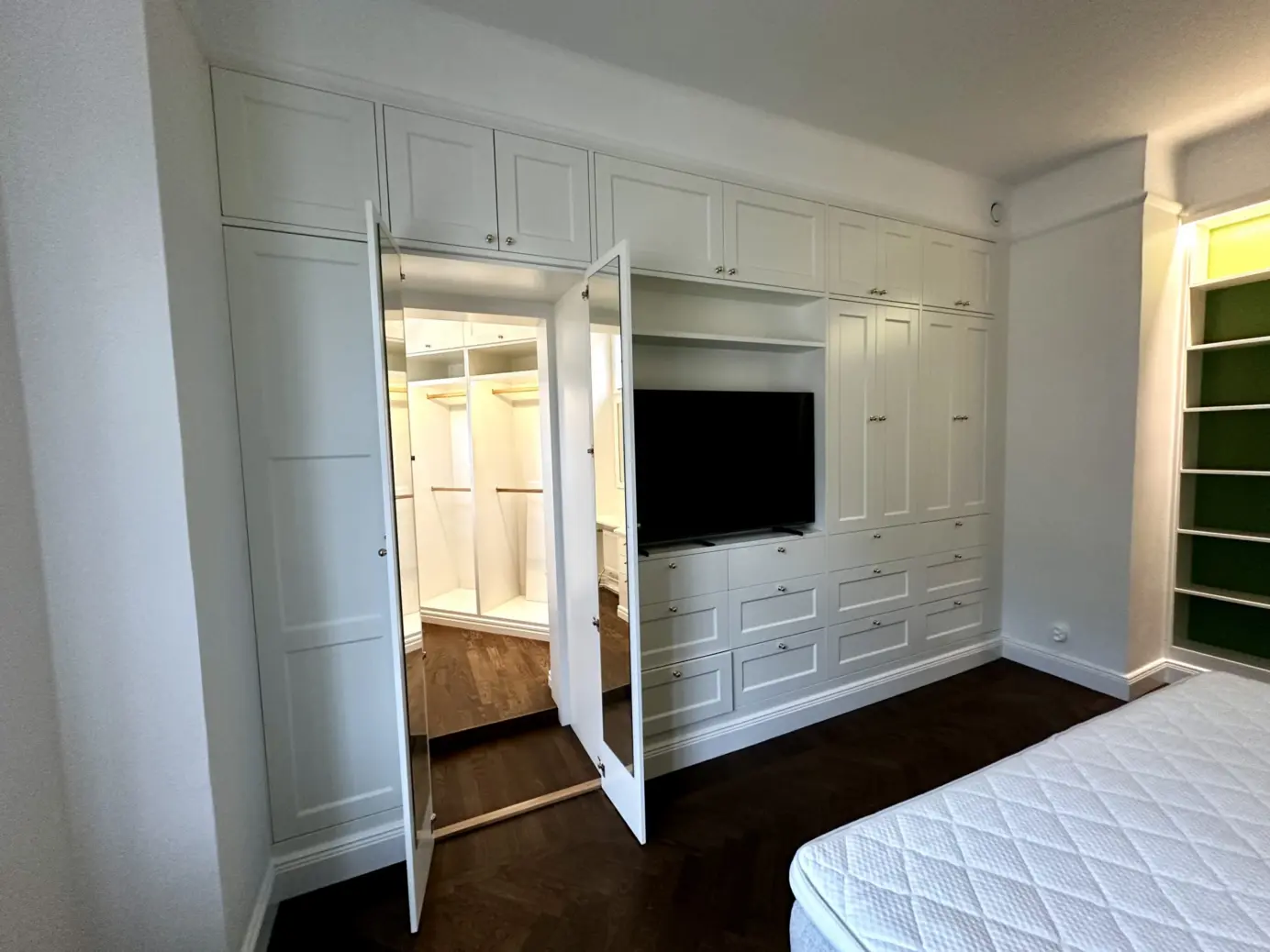 Platsbyggd garderobsvägg med dörr till ett walk in closet