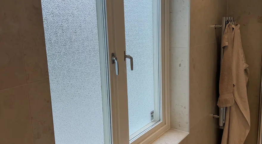 Fönster med frostat glas i badrum